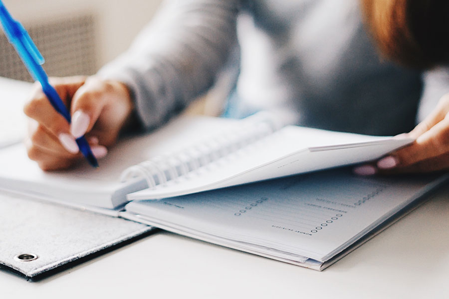 Image of a woman writing in a finance journal